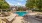a pool with tables and chairs next to it